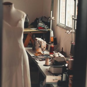 A warm, inviting home sewing room with a dress form and sewing machines at work.